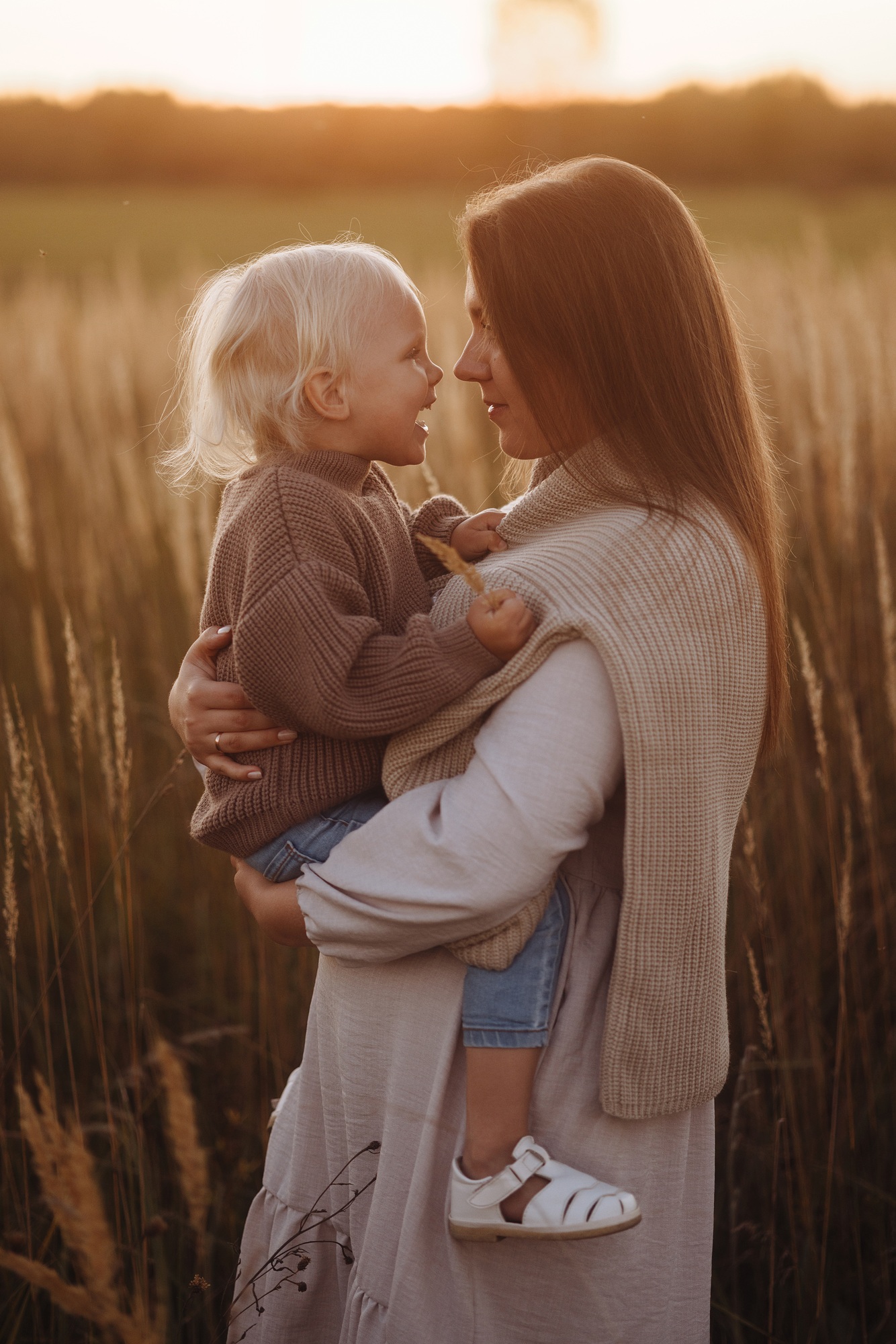 Side view Happy Mother and Child in Sunset Field
